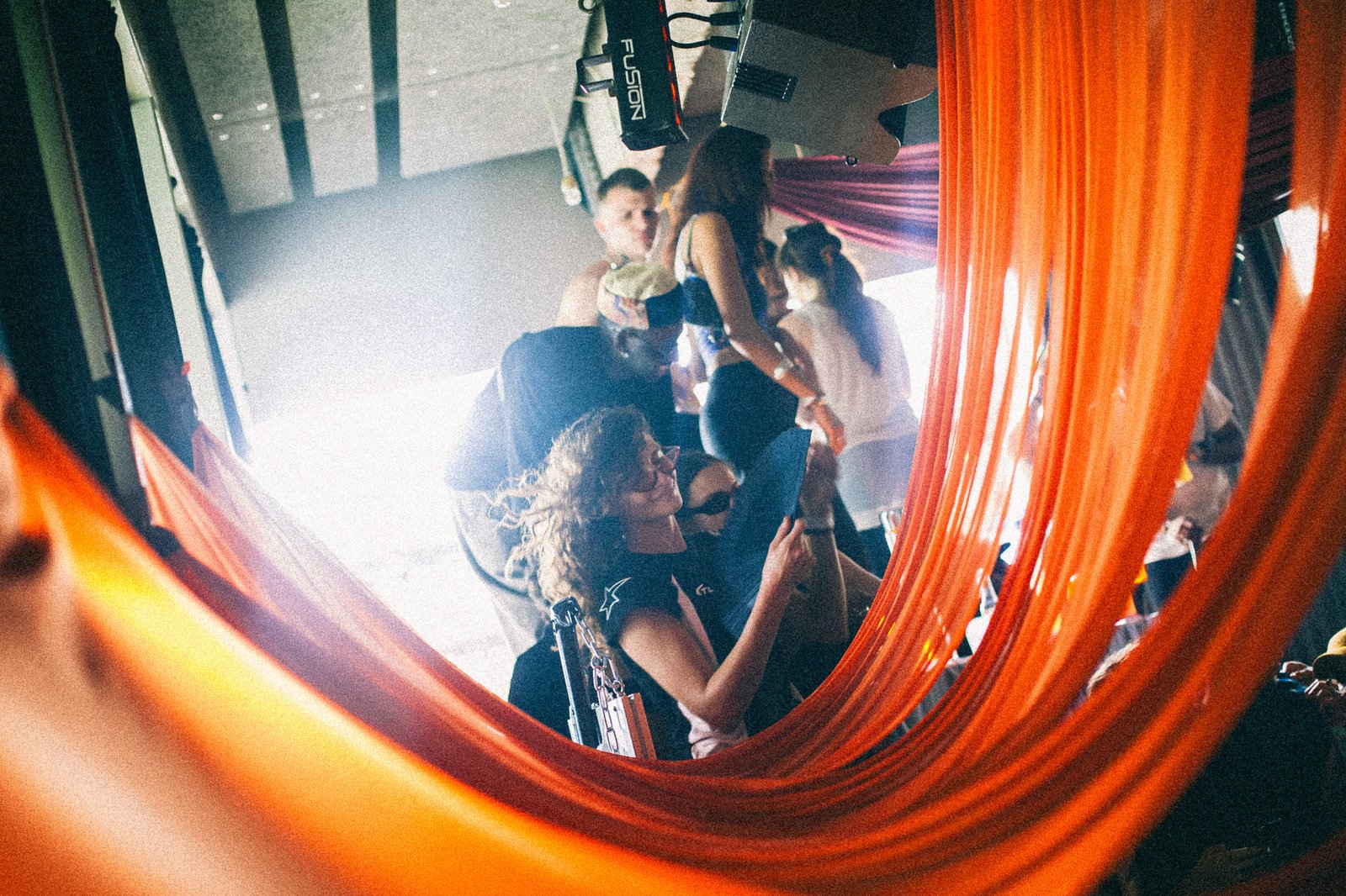 Guests seen through a sweep of orange fabric in the foreground