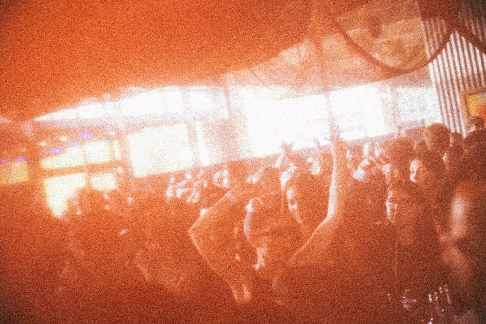 Hands in the air in an orange haze in front of the windows