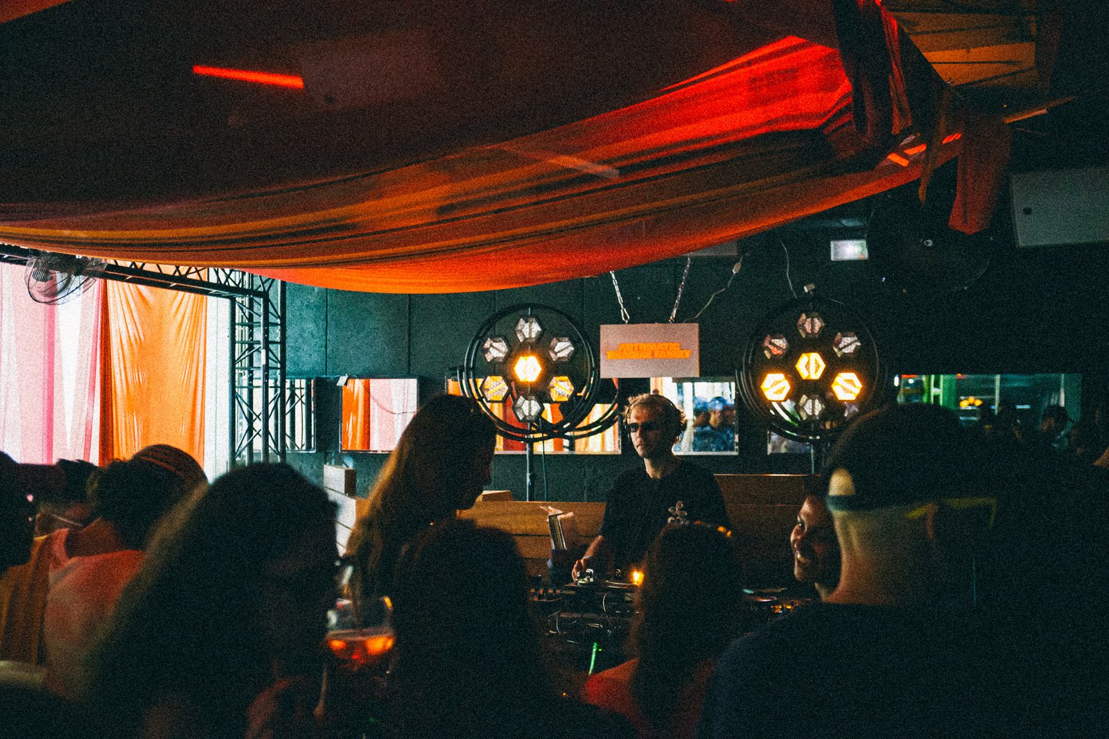 Two ring lights above the booth, drapes in orange and white behind