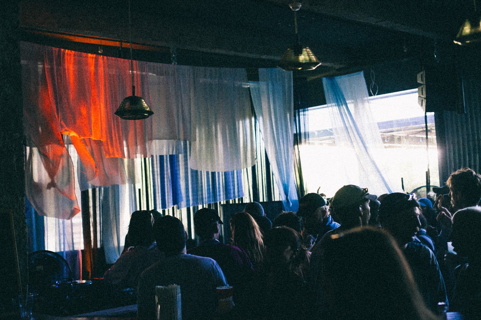 Draped white and blue fabrics against the windows, the crowd in silhouette